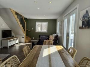 a dining room with a table and a living room at Chalet de la Roche Plate in Saint-Raymond