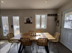 a dining room with a wooden table and chairs at Chalet de la Roche Plate in Saint-Raymond