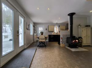 a living room with a table and a stove at Chalet de la Roche Plate in Saint-Raymond
