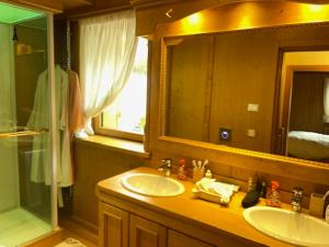 a bathroom with two sinks and a mirror and a shower at Chalet Luxury Pelmo in San Vito di Cadore +16 photos
