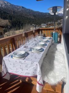 a table with plates on it on a balcony at Chalet Luxury Pelmo in San Vito di Cadore