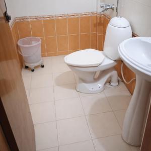 un bagno con un water e un lavandino di Hotel Madhushree Morning Moon In - Restaurant & Free Parking Facilities - Best Premium Hotel In Bhimtal a Bhimtal Altre 8 foto