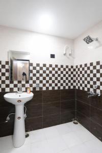 un bagno con lavandino e piastrelle a scacchi bianchi e neri di Hotel Madhushree Morning Moon In - Restaurant & Free Parking Facilities - Best Premium Hotel In Bhimtal a Bhimtal