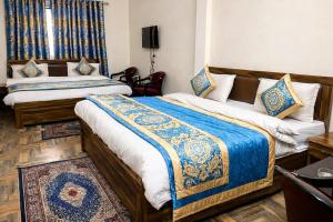 una camera con due letti con coperte bianche e blu di Hotel Madhushree Morning Moon In - Restaurant & Free Parking Facilities - Best Premium Hotel In Bhimtal a Bhimtal