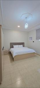 a bedroom with a large bed with a ceiling at شقق النزهة الفندقيه in Riyadh Al Khabra