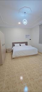 a bedroom with a large white bed in a room at شقق النزهة الفندقيه in Riyadh Al Khabra