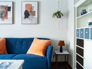 a blue couch in a white living room at Buodden Rorbuer - Fisherman Cabins Sørvågen in Sørvågen