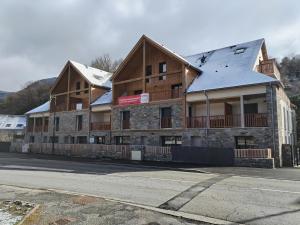 ein großes Gebäude mit Schnee darüber in der Unterkunft Gites Le bois des Tréans in Les Moutiers