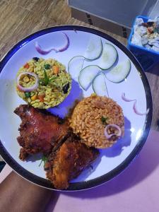 een bord met vlees, rijst en groenten bij De Generals Hotel in Ibadan