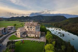 una vista aerea di una grande casa su un prato vicino a un fiume di Casas Pirineo, Ainsa ad Aínsa