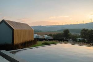 een zwembad voor een gebouw met windmolens bij The Posh Khao Kho in Ban Nong Chaeng