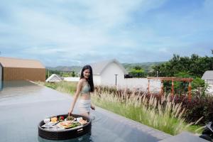 een vrouw staat in het water naast een mand met eten bij The Posh Khao Kho in Ban Nong Chaeng