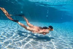 een persoon zwemt in het water bij The Posh Khao Kho in Ban Nong Chaeng