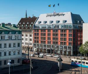 a large red building in a city with cars at ProfilHotels Opera in Gothenburg