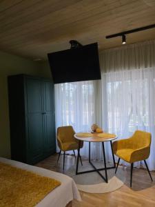 a bedroom with a table and chairs and a bed at Tähetee Majake in Palometsa