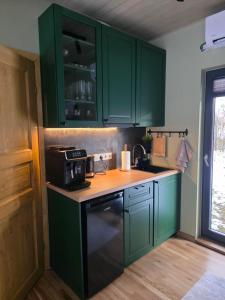 een keuken met groene kasten en een spoelbak bij Tähetee Majake in Palometsa