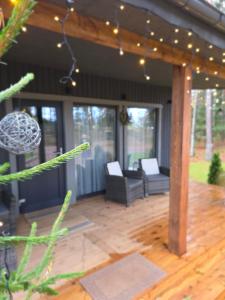 een afgeschermde veranda met een houten terras voorzien van meubilair bij Tähetee Majake in Palometsa