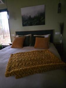 een slaapkamer met een groot bed met een deken erop bij Tähetee Majake in Palometsa