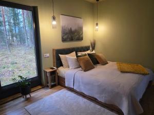 een slaapkamer met een bed en een groot raam bij Tähetee Majake in Palometsa