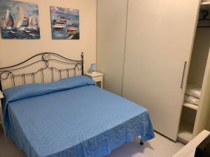 a bedroom with a bed with a blue bedspread at LucevanLeStelle - Full Comfort Quiet Apartment by the Promenade in Viareggio