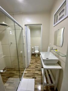 um banheiro com pia, chuveiro e vaso sanitário em Vila Goa em Cruz