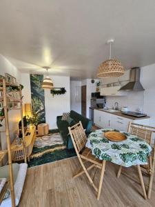 een keuken en een woonkamer met een tafel en stoelen bij Gîte "Bornéo", avec parking securisé in La Roche-sur-Yon