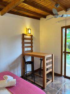 een kamer met een houten bureau en een bed bij palmaresuites in Imbituba +2 foto's