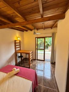 een slaapkamer met een bed en een bureau met een tafel bij palmaresuites in Imbituba