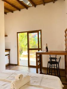 een kamer met 2 bedden en een tafel met een raam bij palmaresuites in Imbituba