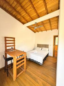 een slaapkamer met een bed en een houten tafel bij palmaresuites in Imbituba