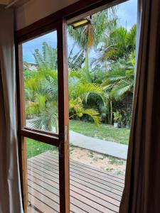 een open deur naar een terras met palmbomen bij palmaresuites in Imbituba