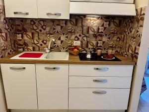 a kitchen with white cabinets and a sink at LucevanLeStelle - Full Comfort Quiet Apartment by the Promenade in Viareggio
