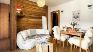 un soggiorno con mobili bianchi e una parete in legno di Melba Megeve emplacement de rêve dans le village au calme a Megève