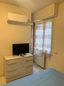 a bedroom with a bed and a television on a dresser at LucevanLeStelle - Full Comfort Quiet Apartment by the Promenade in Viareggio