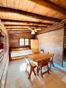 a room with a wooden table and a bed at Guathemoc cabañas in Panaholma