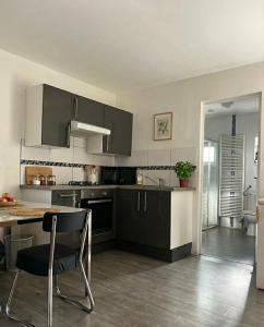 een keuken met grijze kasten en een tafel en stoelen bij One City Lodge in Illkirch-Graffenstaden