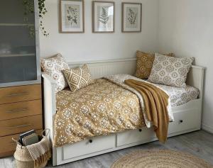 een slaapkamer met een bed met kussens en een televisie bij One City Lodge in Illkirch-Graffenstaden