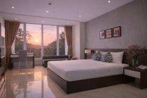 a bedroom with a large bed and a balcony at Golden Queen Aparthotel in Ho Chi Minh City