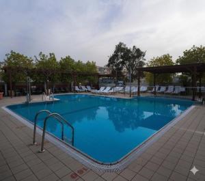 a large blue swimming pool with chairs on a resort at Kinorot Hotel in Tiberias