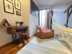 a living room with a hammock chair and a desk at Descubra a Casa Felicidade em Belém! Climatizada, com sala ampla, 2 quartos, mezanino e Wi-Fi veloz. Localização central perto de atrações e gastronomia. Viva a Amazônia com conforto exclusivo. Reserve já sua experiência inesquecível! in Curro Velho