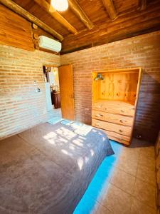 a bedroom with a large bed and a brick wall at Guathemoc cabañas in Panaholma +8 photos
