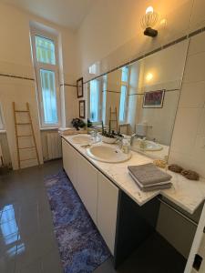 een badkamer met 3 wastafels en een grote spiegel bij Il Gelsomino "Meraviglioso appartamento in villa Liberty" in Gorizia +38 foto's