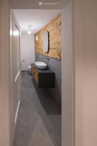 une salle de bains avec un lavabo et un miroir dans l'établissement Historisches Bijou in Beromünster, Golf & Luzern, à Beromünster