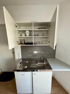 een kleine keuken met een fornuis en witte kasten bij Moderne Ferienwohnung nahe Bostalsee in Nohfelden