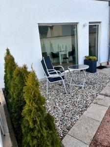 een paar stoelen en een tafel op een grindterras bij Moderne Ferienwohnung nahe Bostalsee in Nohfelden +5 foto's