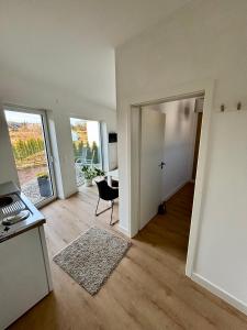 een lege woonkamer met een tafel en een stoel bij Moderne Ferienwohnung nahe Bostalsee in Nohfelden