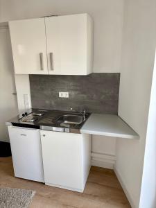 een keuken met witte kasten en een spoelbak bij Moderne Ferienwohnung nahe Bostalsee in Nohfelden