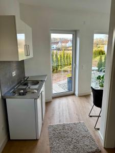 een keuken met een fornuis en een deur naar een patio bij Moderne Ferienwohnung nahe Bostalsee in Nohfelden