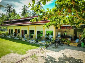 a building with a bunch of chairs in front of it at CocoVille Guesthouse Couple Room in Alegria