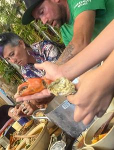 een groep mensen die rond een tafel met eten staan bij The peace home in Tấn Tài